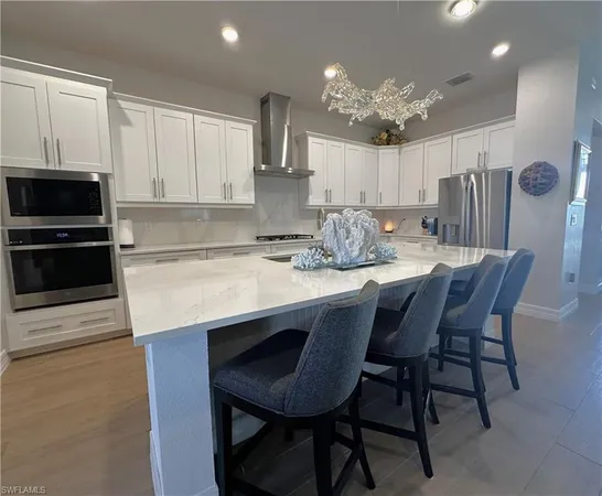 a kitchen with a dining table chairs stainless steel appliances and cabinets