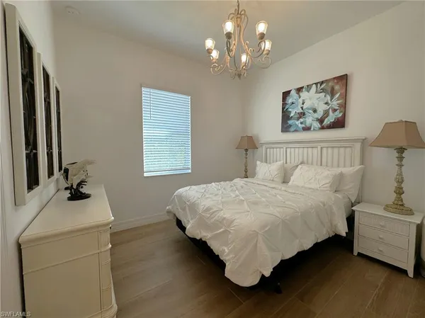 a bedroom with a bed wooden floor and window