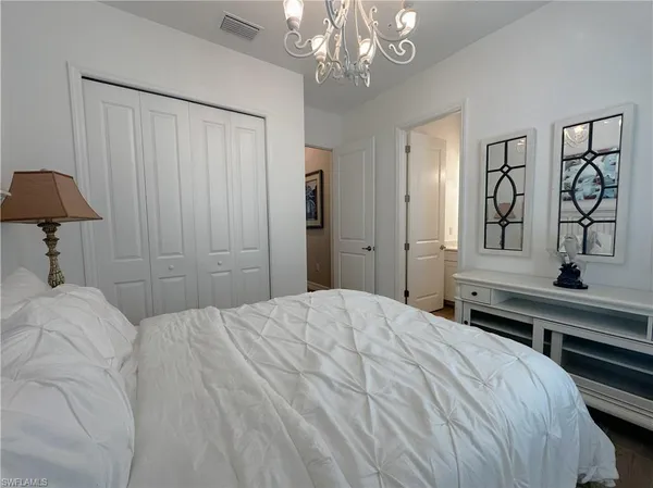 a bedroom with a large bed and a chandelier