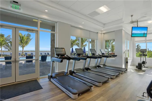 a living room with furniture gym equipment and large windows