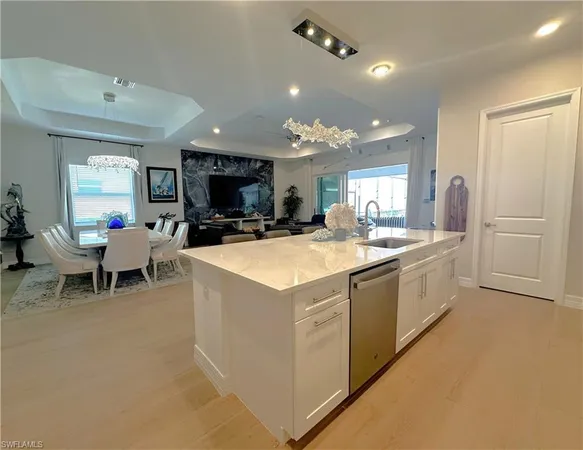a large white kitchen with kitchen island a sink a stove and a refrigerator
