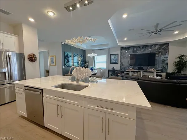 a kitchen with stainless steel appliances granite countertop a sink and a refrigerator