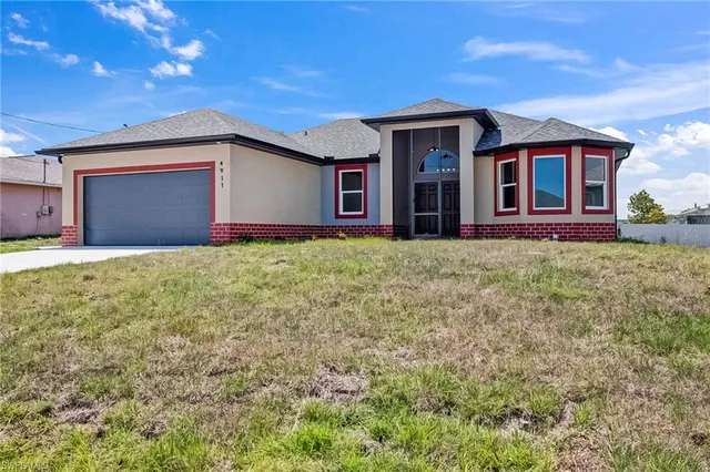 a front view of house with yard and garage