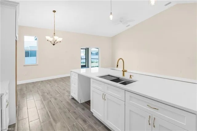 a kitchen with a sink and chandelier