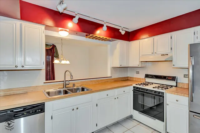 a kitchen with granite countertop a sink stainless steel appliances and cabinets