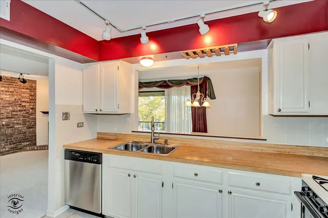 a kitchen with stainless steel appliances granite countertop a sink and a refrigerator
