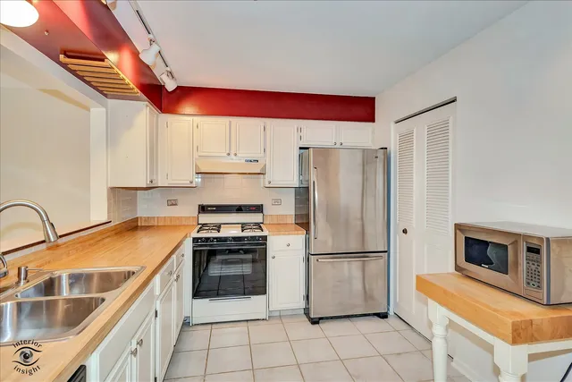 a kitchen with granite countertop a refrigerator and a stove top oven
