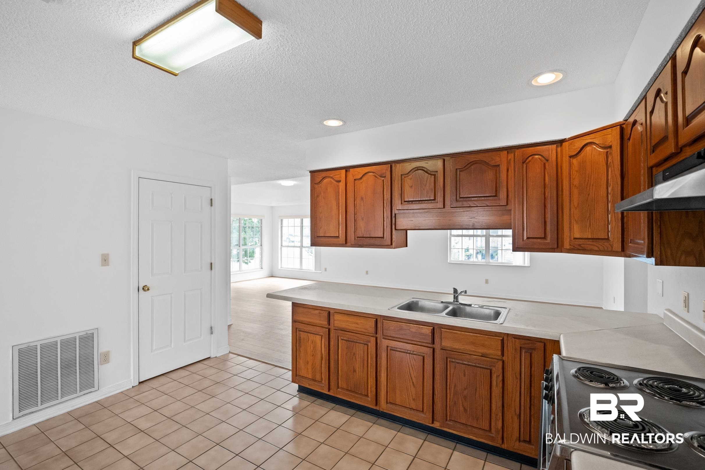 2673 Pine Ridge Drive Lillian, AL 36549 - Photo 8 of 38 Kitchen with a sink, visible vents, stainless steel electric range, and brown cabinetry