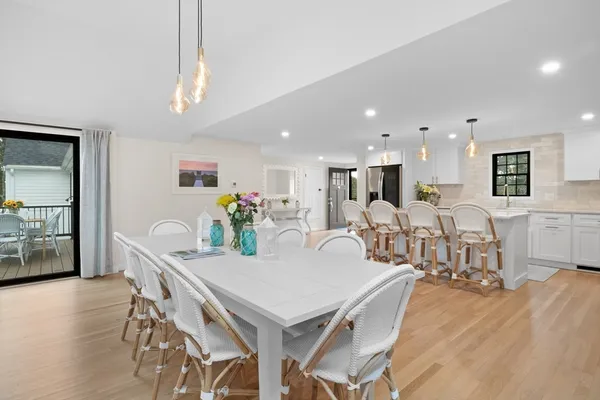 a living room with furniture kitchen view and a wooden floor