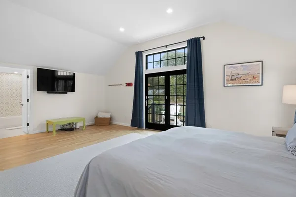 a spacious bedroom with a bed and a window