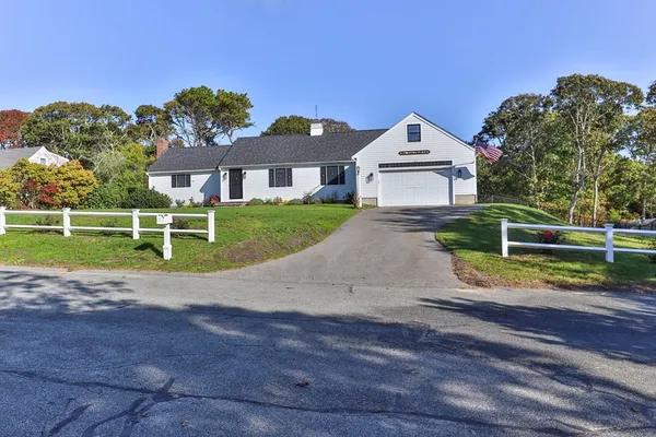 a view of a house with a big yard and large trees