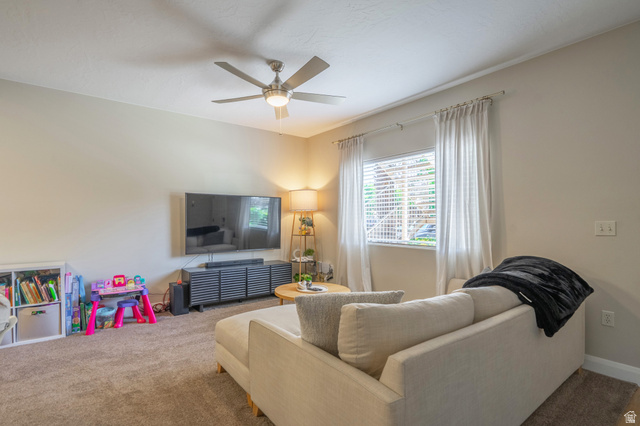 700 North Main Street, Unit F3 Washington, UT 84780 - Photo 3 of 34 Carpeted living area featuring a ceiling fan with integrated lighting, a window with blinds and drapes, and neutral wall tones