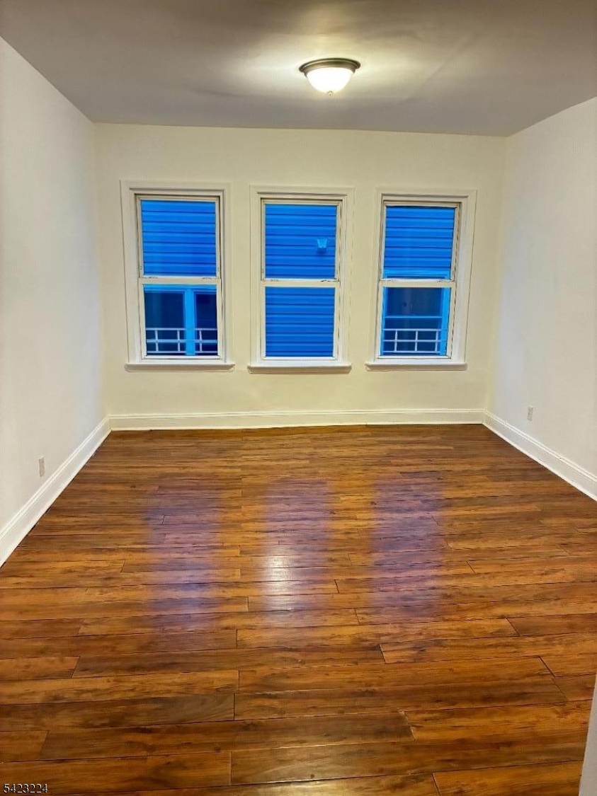 73 Wolcott Terrace Newark, NJ 07112 - Photo 1 of 20 a view of an empty room with wooden floor and windows