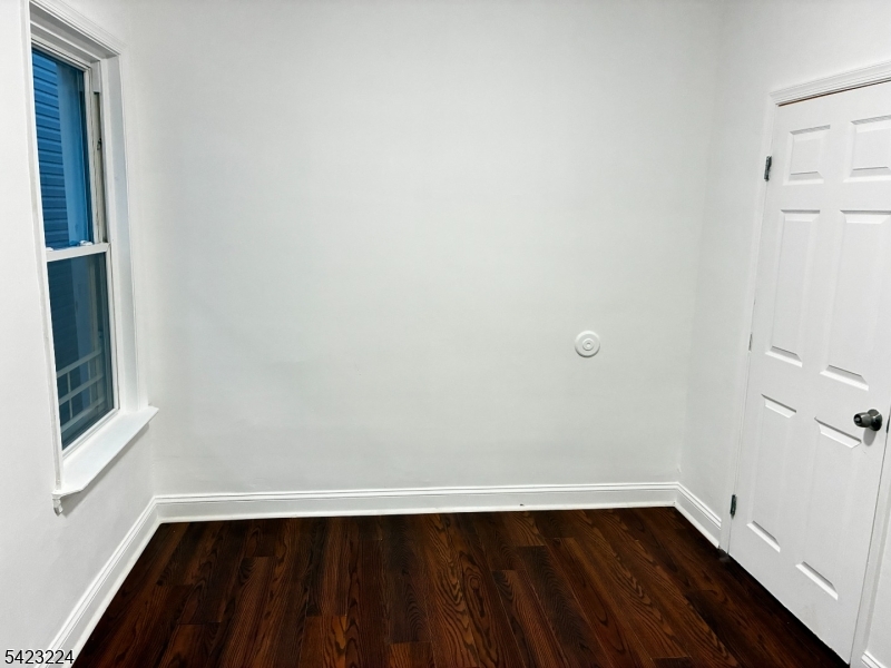 73 Wolcott Terrace Newark, NJ 07112 - Photo 11 of 20 a view of an empty room with wooden floor and a window