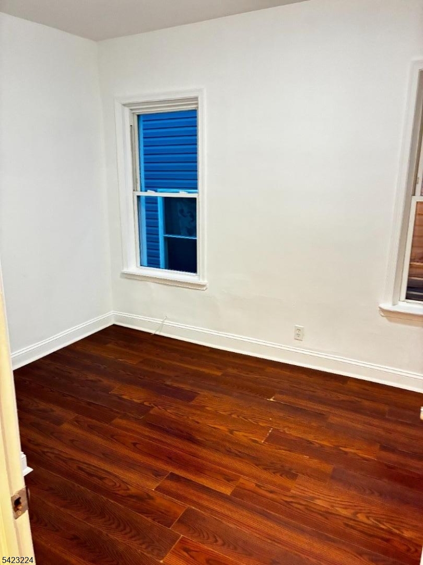 73 Wolcott Terrace Newark, NJ 07112 - Photo 12 of 20 a view of an empty room with wooden floor and a window