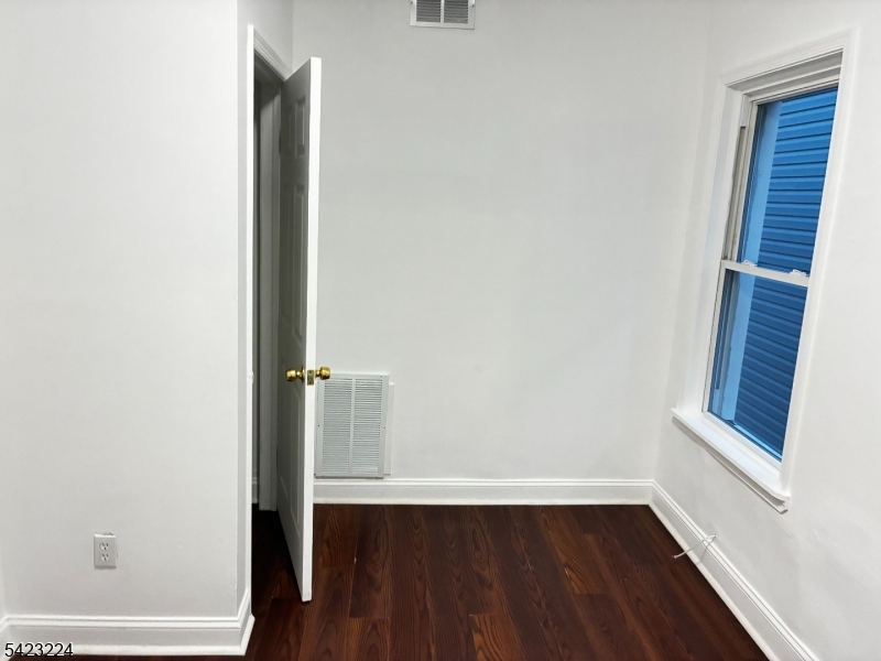 73 Wolcott Terrace Newark, NJ 07112 - Photo 13 of 20 a view of an empty room with wooden floor and a window