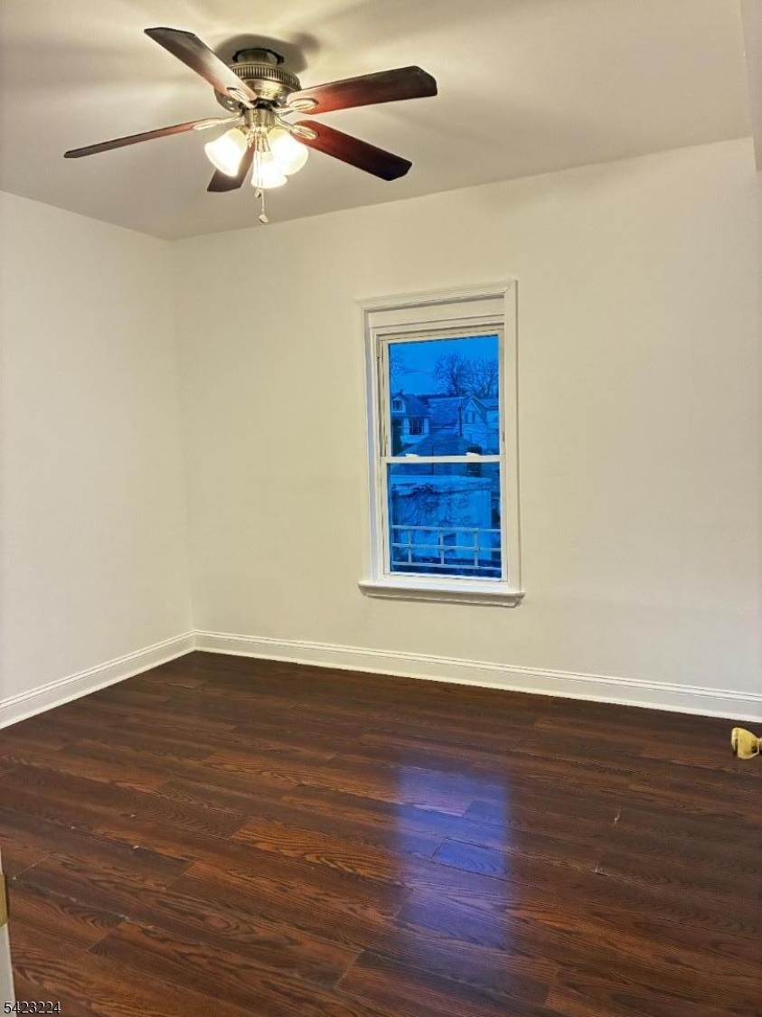 73 Wolcott Terrace Newark, NJ 07112 - Photo 17 of 20 a view of an empty room with wooden floor and a ceiling fan