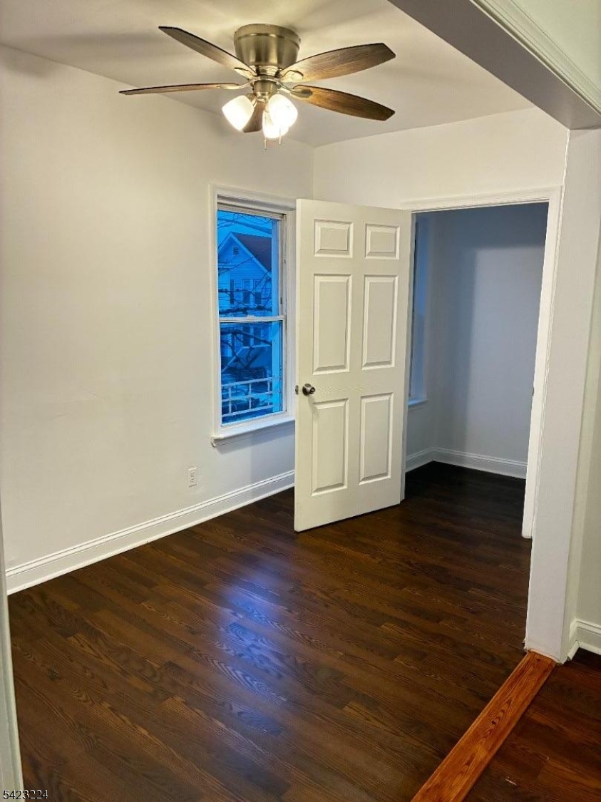 73 Wolcott Terrace Newark, NJ 07112 - Photo 5 of 20 a view of an empty room with wooden floor and a ceiling fan