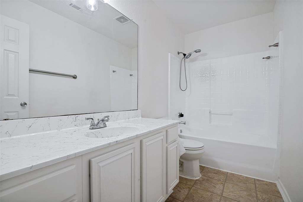 3111 Creekside Drive Sachse, TX 75048 - Photo 20 of 25 Bathroom featuring a white vanity with panel cabinetry and a light-toned countertop, an integrated sink with a chrome faucet, and a large wall-mounted mirror