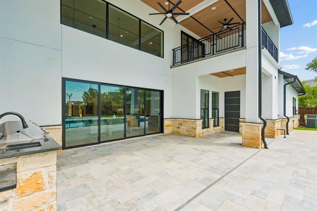 6606 Curtis Road Colleyville, TX 76034 - Photo 33 of 39 Expansive patio featuring stone tile flooring, an outdoor grilling station with granite countertop, and full-height sliding glass doors