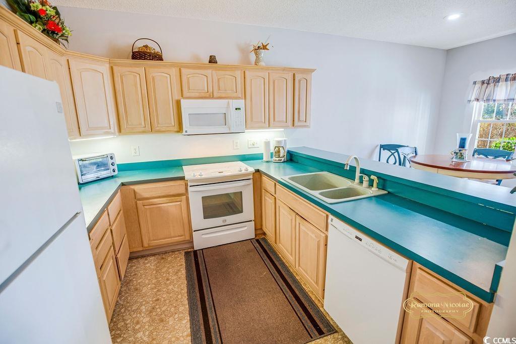 2203 Sweetwater Boulevard, Unit 2203 Murrells Inlet, SC 29576 - Photo 11 of 23 Kitchen with white appliances, a toaster, a textured ceiling, light brown cabinets, and a sink