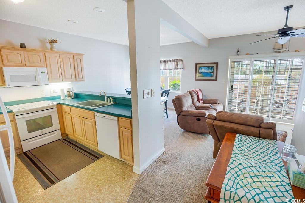 2203 Sweetwater Boulevard, Unit 2203 Murrells Inlet, SC 29576 - Photo 23 of 23 Kitchen featuring a textured ceiling, white appliances, a sink, open floor plan, and light brown cabinetry