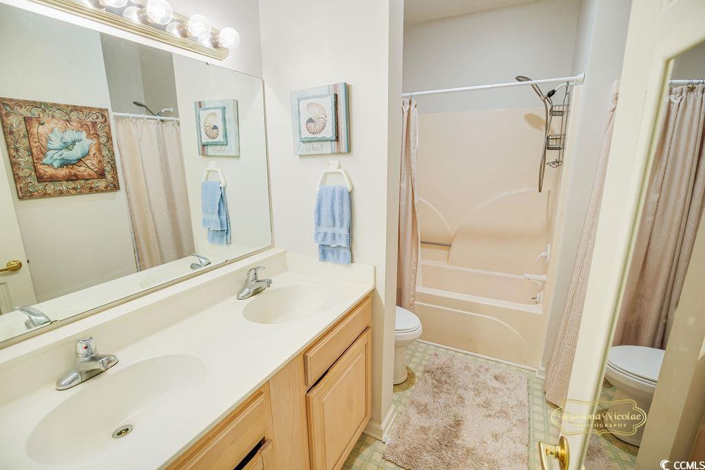2203 Sweetwater Boulevard, Unit 2203 Murrells Inlet, SC 29576 - Photo 13 of 23 Full bathroom with toilet, shower / bath combination with curtain, double vanity, and a sink