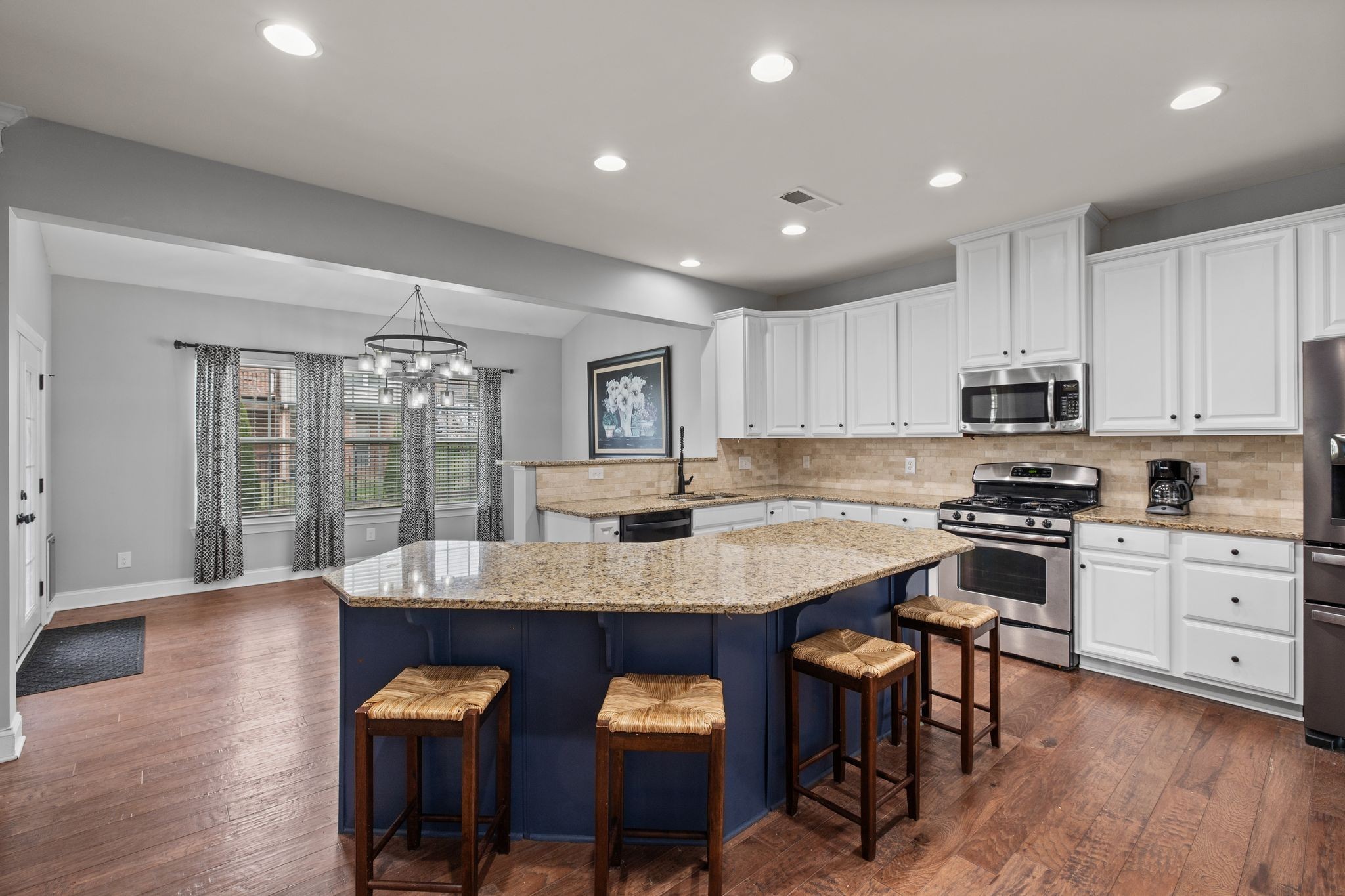 1931 Portview Drive Spring Hill, TN 37174 - Photo 22 of 51 a kitchen with stainless steel appliances granite countertop a stove top oven a sink dishwasher a dining table and chairs with wooden floor