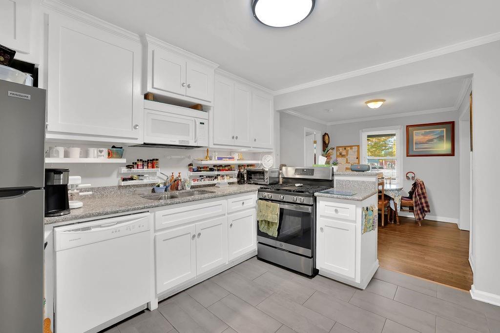 7618 Vaughn Road Woodstock, GA 30188 - Photo 18 of 44 a kitchen with stainless steel appliances granite countertop a sink dishwasher stove and white cabinets