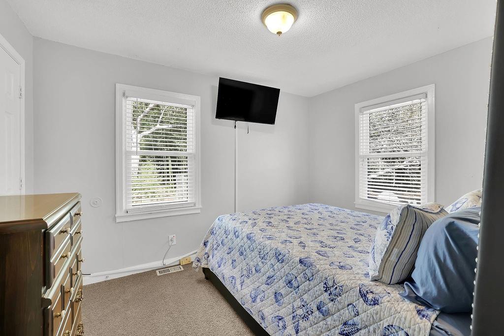 7618 Vaughn Road Woodstock, GA 30188 - Photo 21 of 44 a bedroom with a bed and a flat screen tv