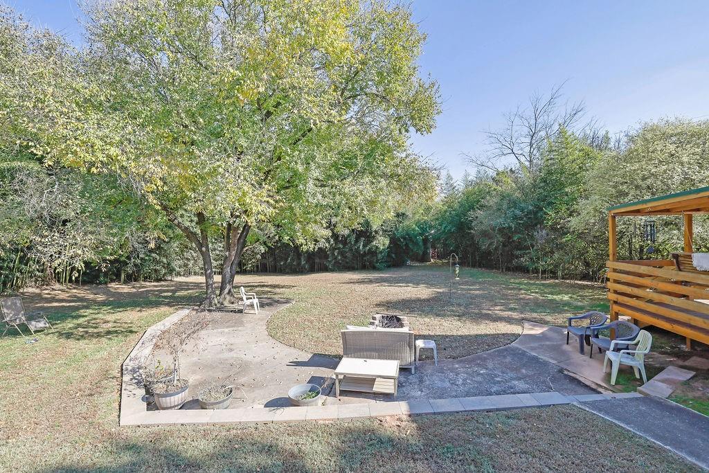 7618 Vaughn Road Woodstock, GA 30188 - Photo 39 of 44 a backyard of a house with trees and outdoor seating