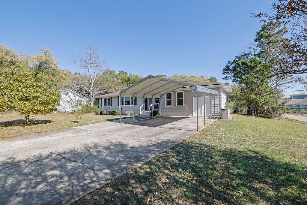 7618 Vaughn Road Woodstock, GA 30188 - Photo 6 of 44 a view of a house with a yard and large trees