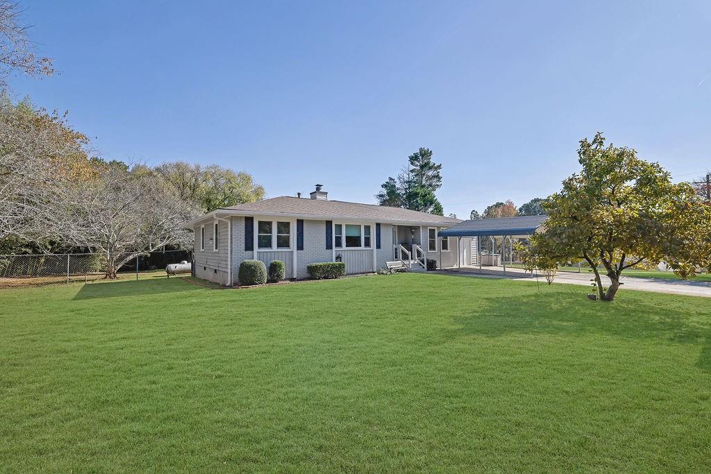 7618 Vaughn Road Woodstock, GA 30188 - Photo 7 of 44 a view of a house with a big yard