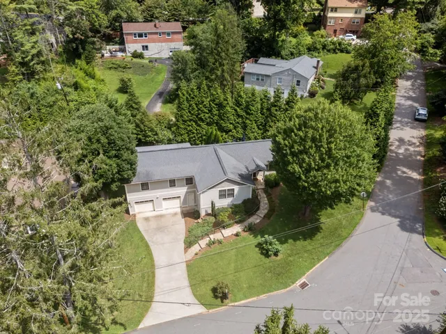 an aerial view of a house with a yard and lake view