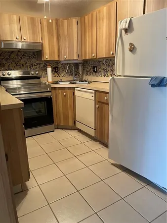 a kitchen with a sink a stove and cabinets