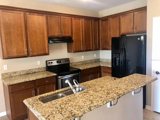 a kitchen with a stove a sink and a refrigerator