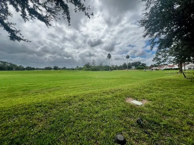an empty room with a chandelier fan and windows