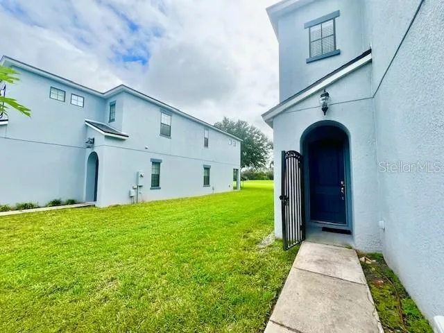 a view of a house with a big yard and large trees
