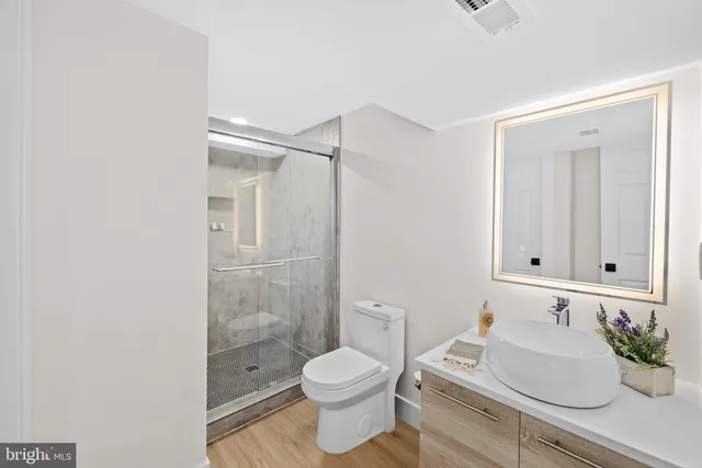 a bathroom with a sink a toilet and shower