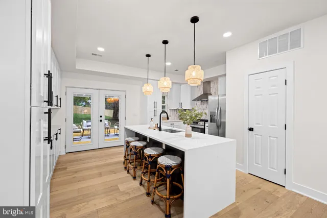a room with stainless steel appliances kitchen island a chandelier and a view of kitchen
