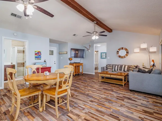 a dining room with wooden floor and a chandelier