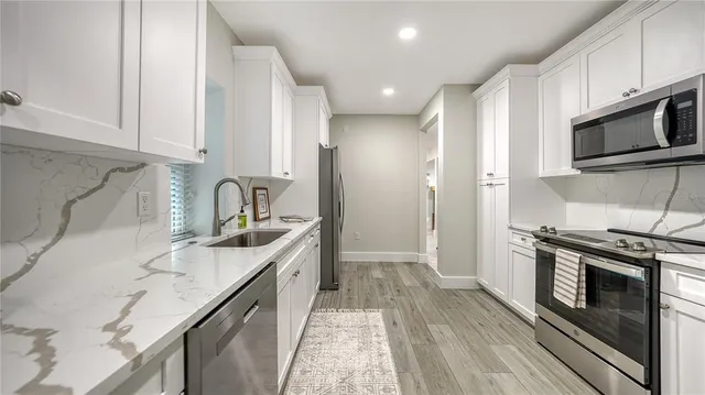 a kitchen with stainless steel appliances granite countertop a sink stove and refrigerator