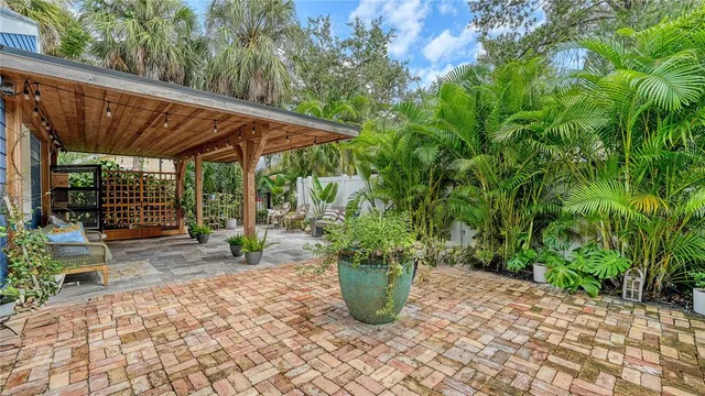 a view of a patio with table and chairs potted plants with wooden fence