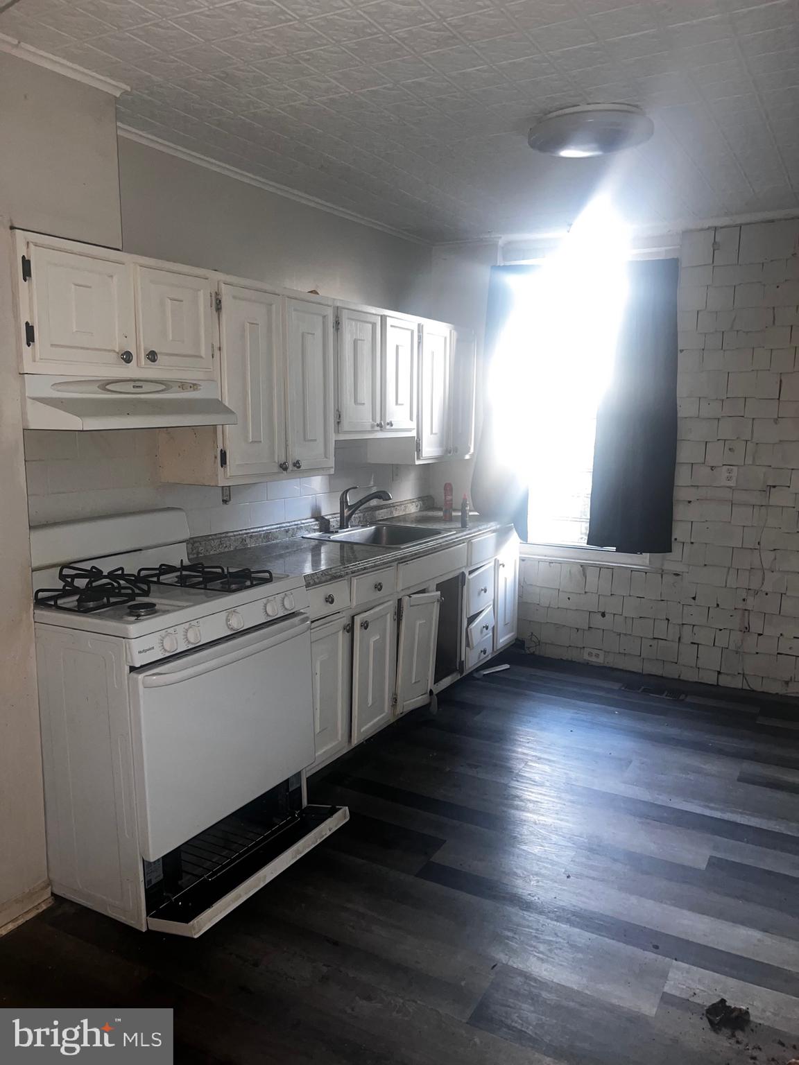 511 North Port Street Baltimore, MD 21205 - Photo 5 of 11 a kitchen with stainless steel appliances granite countertop a sink stove and cabinets