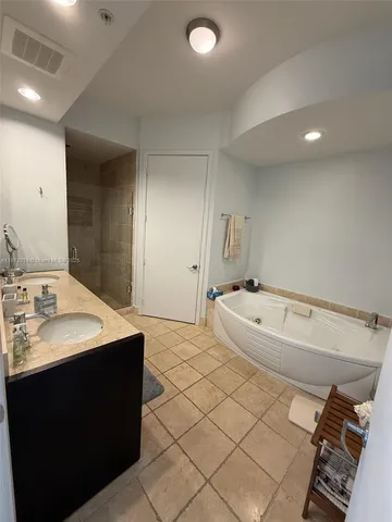 a bathroom with a granite countertop sink a mirror and a shower