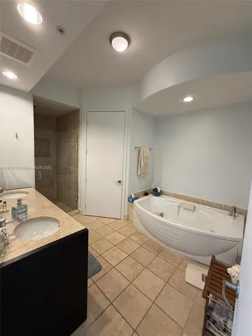 a white toilet sitting next to a bathroom sink and a vanity