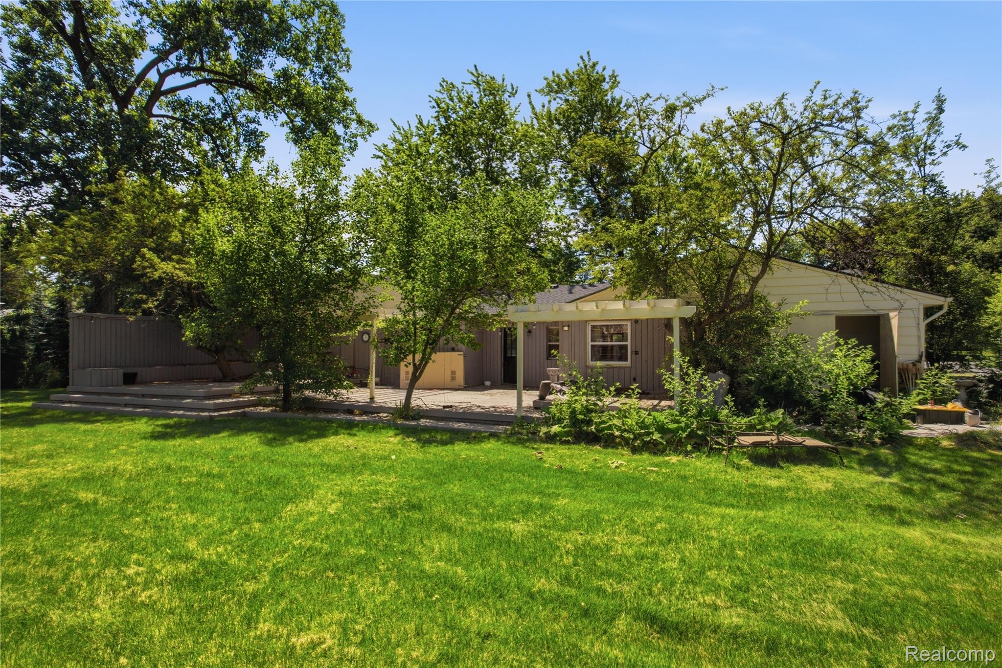3812 Terrybrook Road West Bloomfield, MI 48322 - Photo 32 of 43 Expansive backyard featuring a manicured lawn, established trees, and a multi-level patio