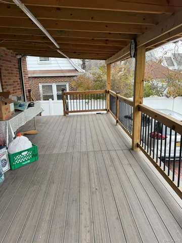 a view of a balcony with wooden floor and outdoor seating
