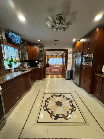 a kitchen with stainless steel appliances granite countertop a sink a stove cabinets and a dining table