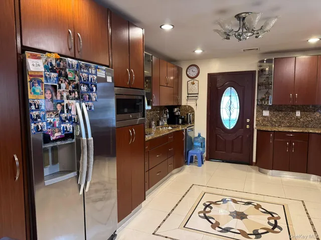 a kitchen with stainless steel appliances kitchen island granite countertop a refrigerator and a stove